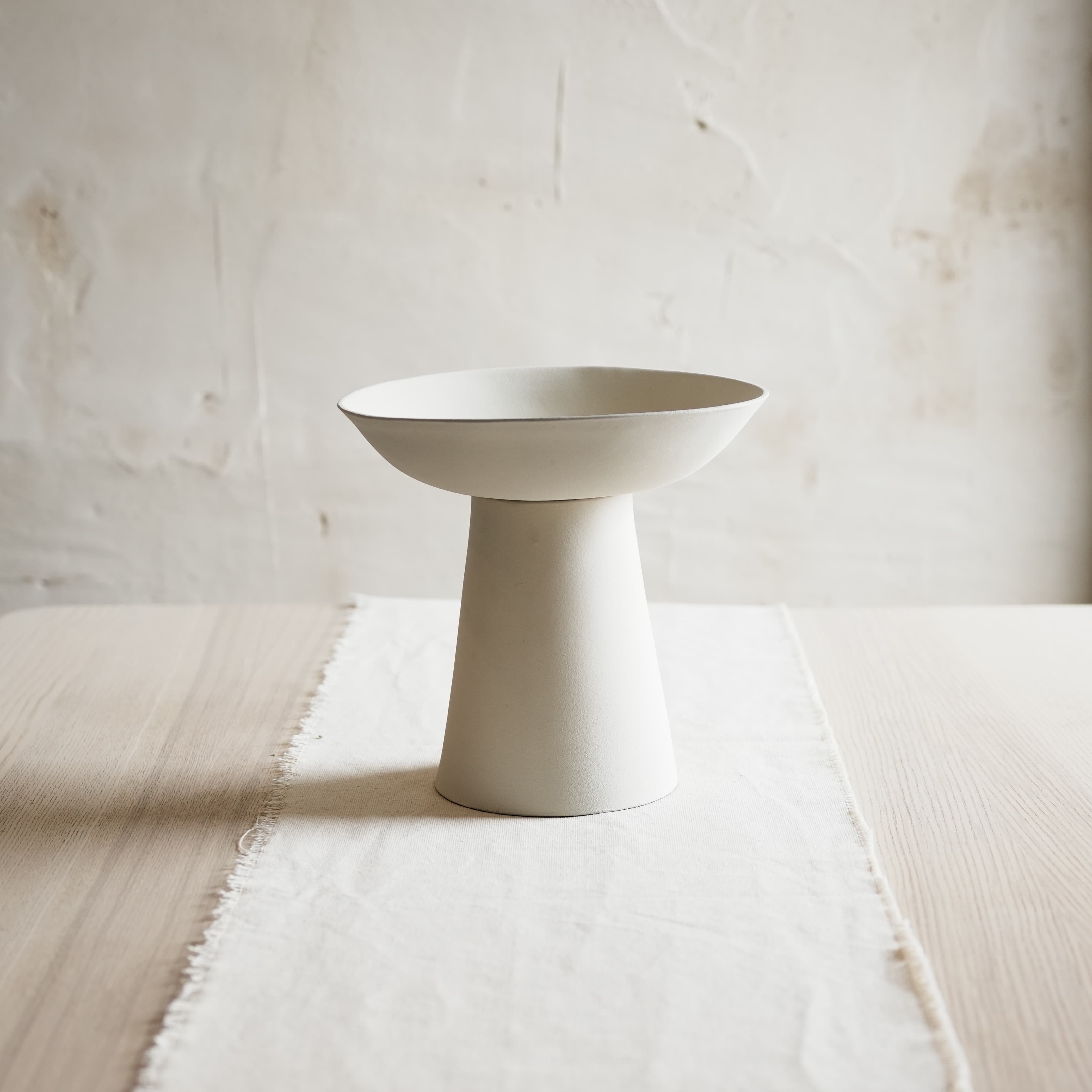 White ceramic bowl on a textured surface with a neutral background