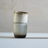 a set of 2 ceramic cups stacks. The rims are a melty light brown and the base is exposed black stoneware