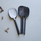 handmade black stoneware spoons with exposed ceramic handles and glazed white matte or glossy gray spoon bowls.