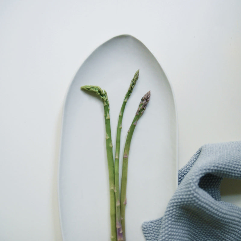 aerial view of white pointed oval plate with asparagus
