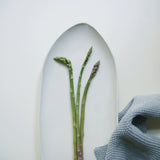 aerial view of white pointed oval plate with asparagus