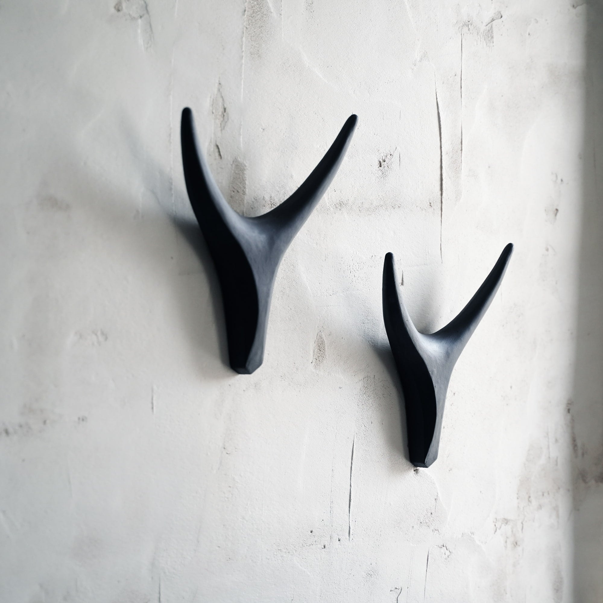 Set of black ceramic antler wall decor sculptures arranged on wall