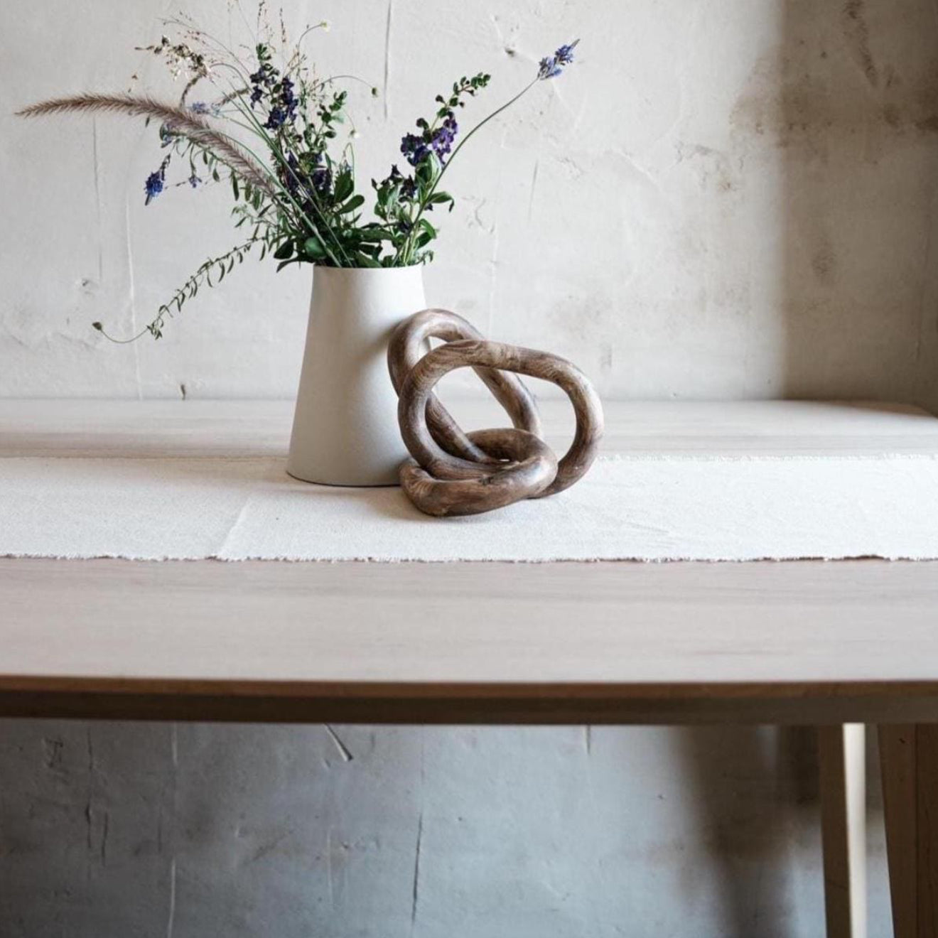 Handmade marbled ceramic chain sculpture in desert tones on wooden shelf
