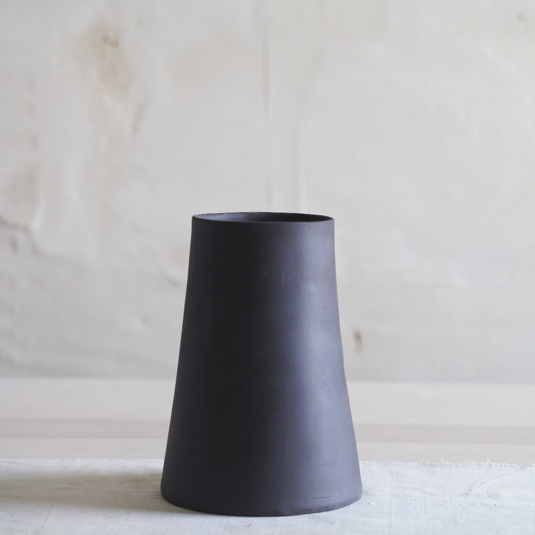 Handmade black ceramic pedestal bowl with footed base, minimalist stoneware centerpiece