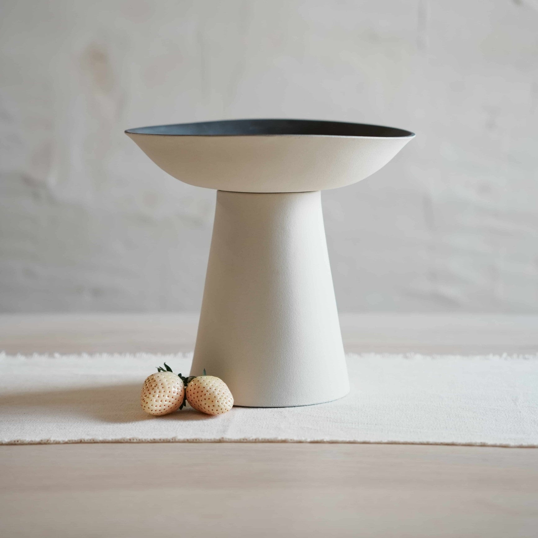 Modern ceramic bowl with a black interior on a white surface