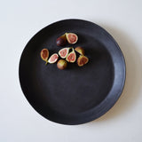 Aerial view of large matte black plate serving apricots