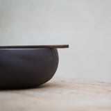 profile view of black ramen bowl with a set of chopsticks