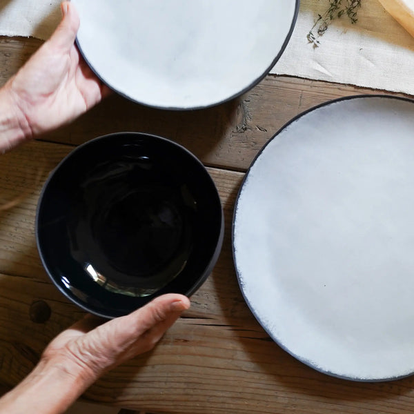 two white plates and a black bowl