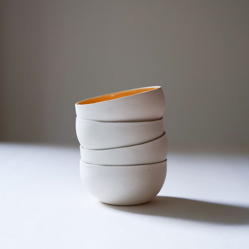 stack of white porcelain bowls. yellow interior