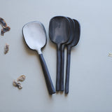 handmade black stoneware spoons with exposed ceramic handles and glazed white matte or glossy gray spoon bowls. 