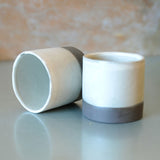 set of 2 white espresso cups. The bases are exposed black stoneware