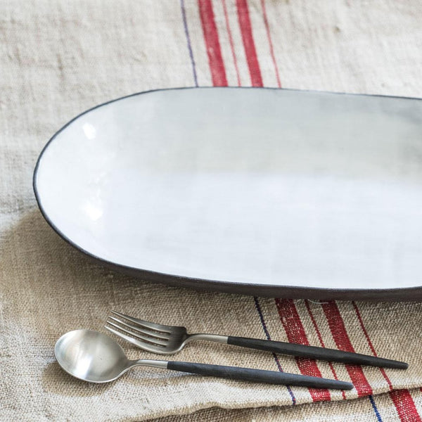 angled view of rounded white serving plate edge