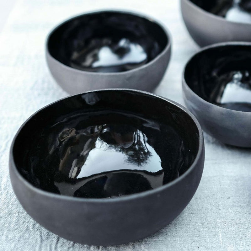 a set of black ceramic bowls, matte on the exterior and shiny on the interior