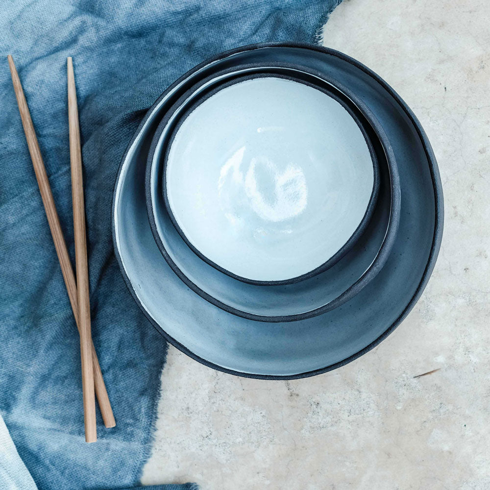 small nedium and large coconut bowls stacked together, styled with chopsticks and photographed from an aerial view